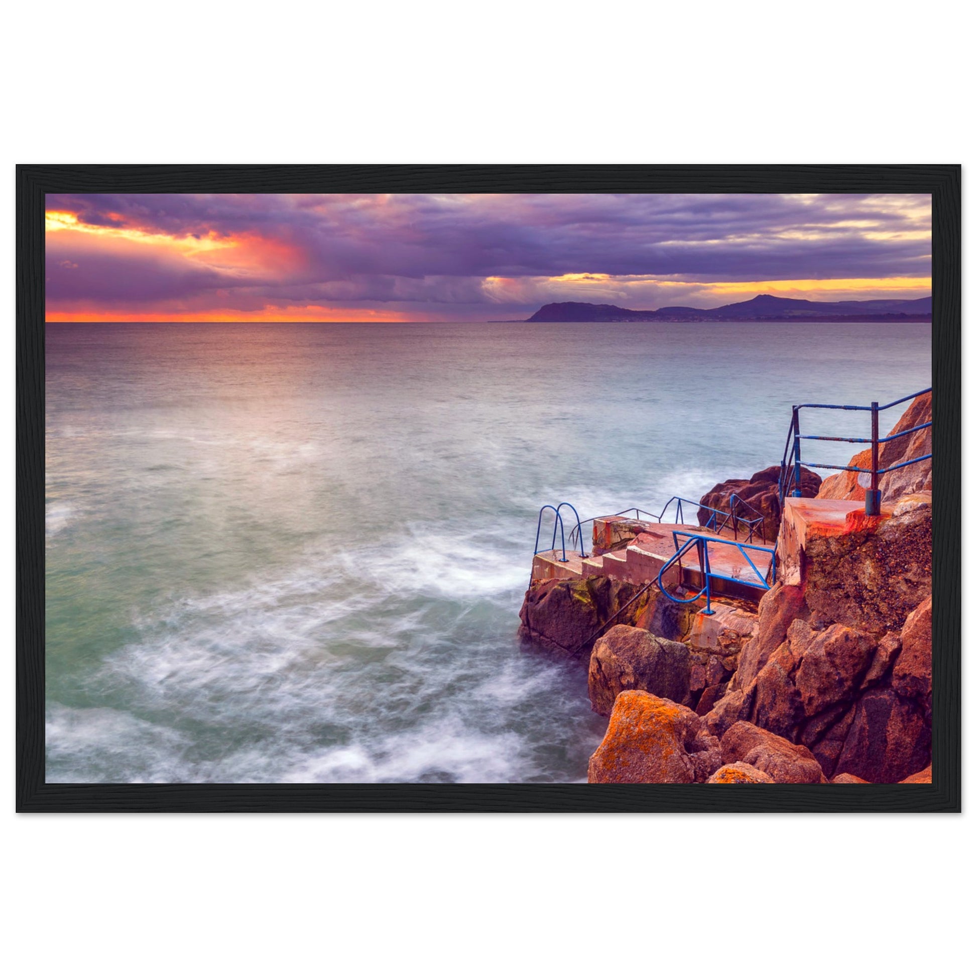 Framed wall art print of Vico Baths in Dalkey, Dublin. Features serene coastal scenery with clear waters and natural rock formations, capturing the iconic outdoor swimming spot. Perfect for adding a touch of Irish coastal beauty to any room.