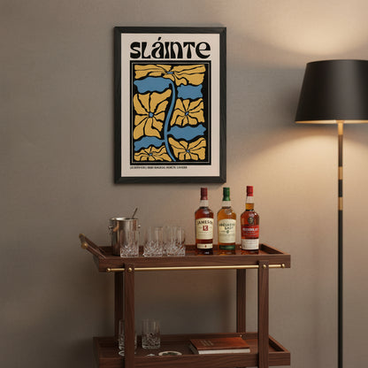 Framed Sláinte print hanging above a wooden bar cart with glasses, whiskey bottles, and soft warm lighting. Premium lifestyle shot.