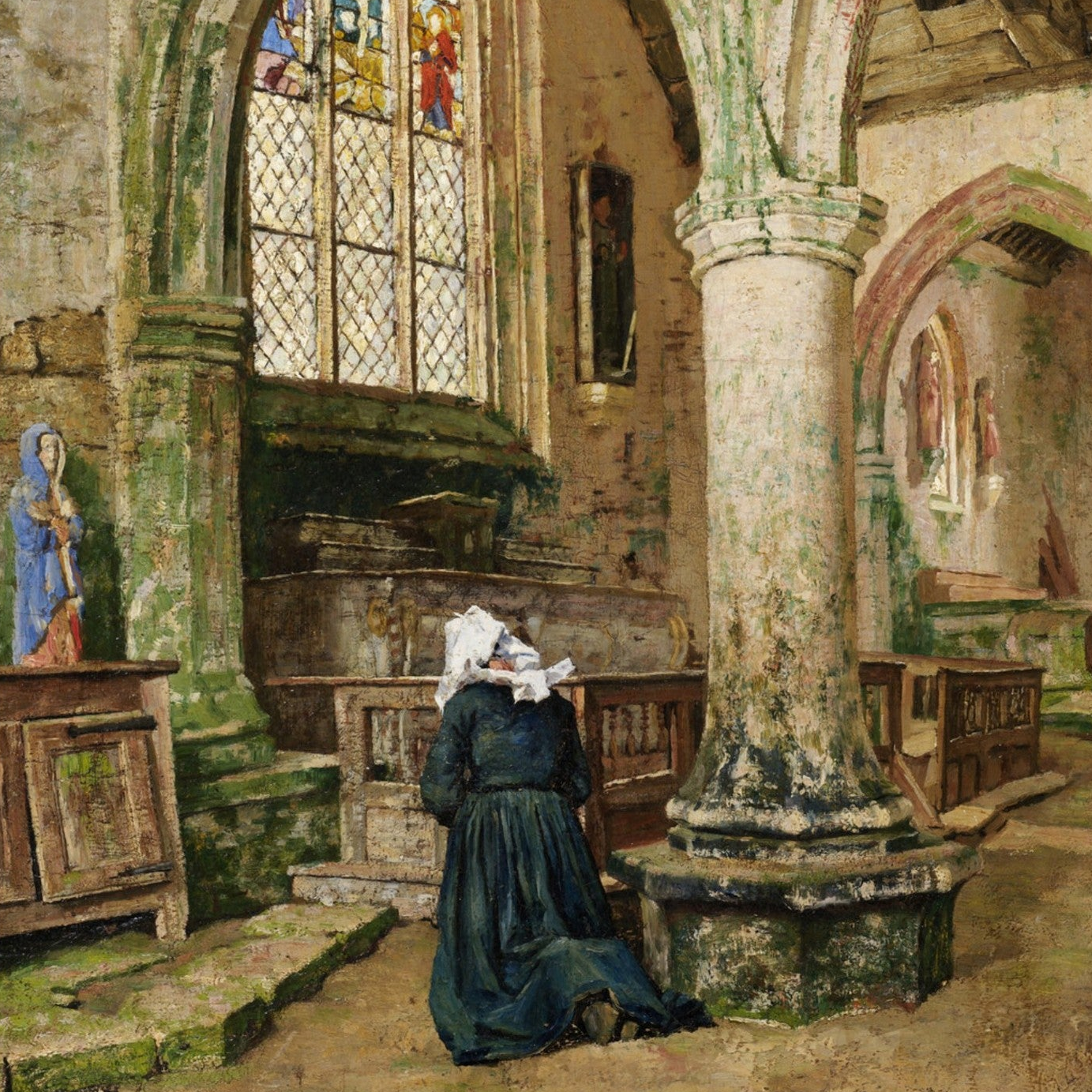 Woman praying in a church interior with stained glass windows and religious statues.